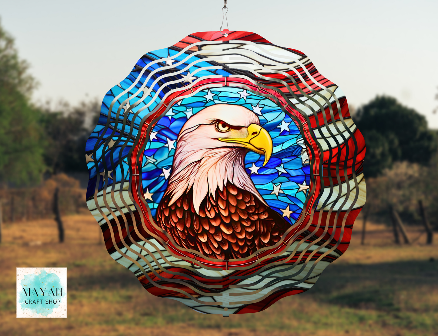 Decorative wind spinner with an eagle design in a field