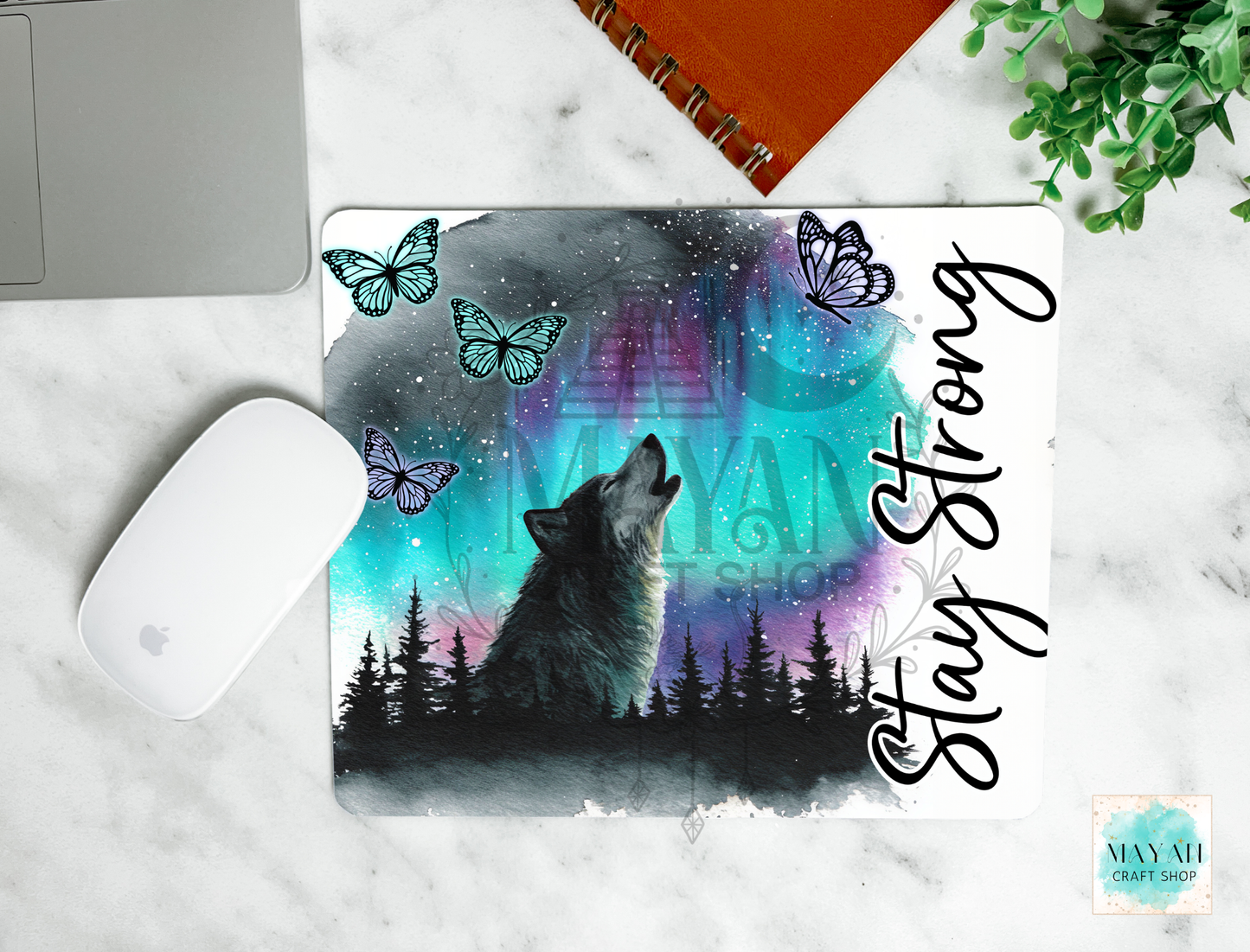 Mouse pad with a wolf and butterfly design on a marble surface