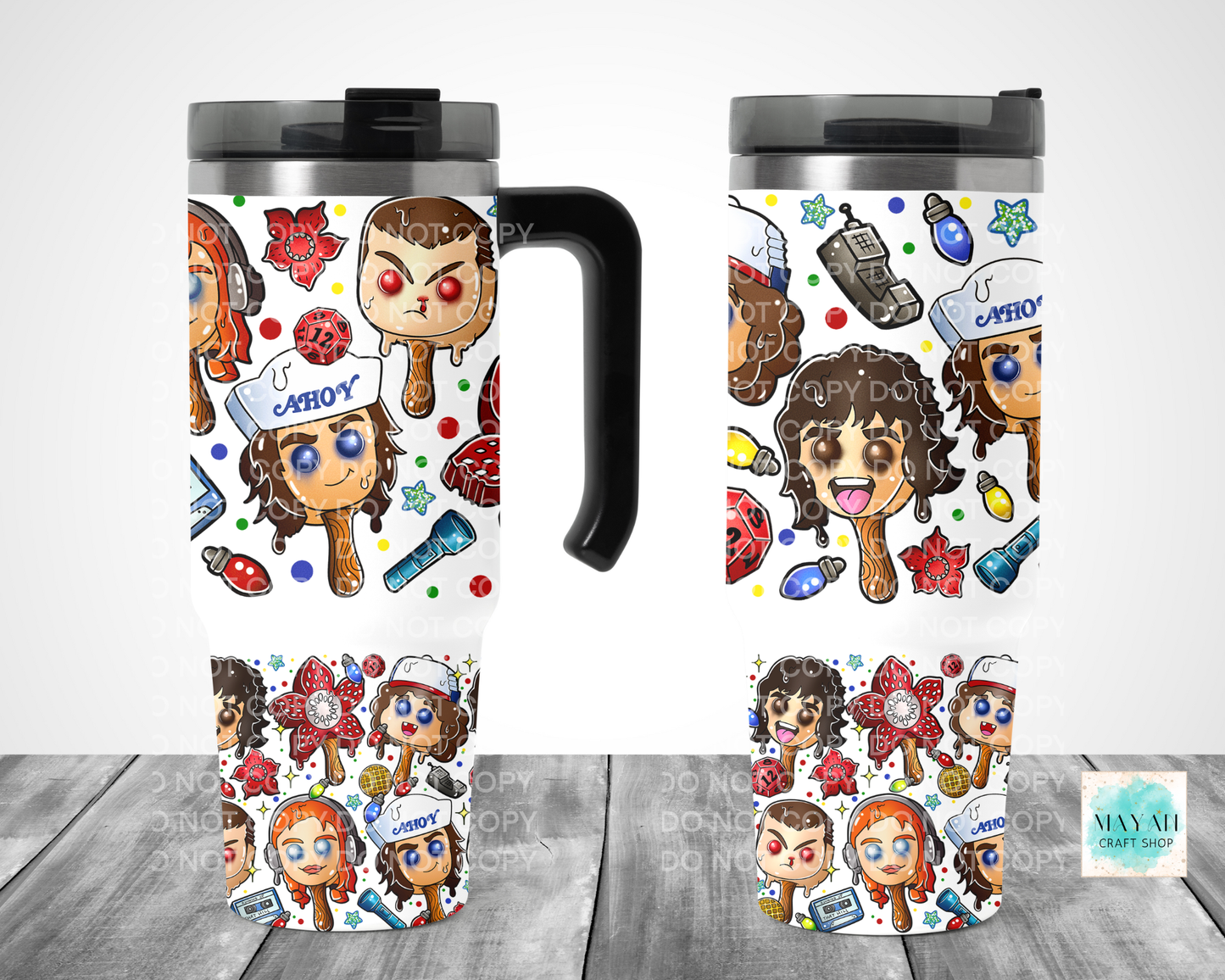 Two travel mugs with cartoon character design on a wooden surface.