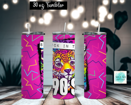 Three views of a 30 oz skinny tumbler with a colorful 90s-style graphic wrap. The design features a bright pink background with neon zig-zag lines, a leopard face illustration, and bold white text reading 'STUCK IN THE 90s'.