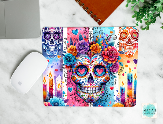 Colorful skull design on a mouse pad with a marble surface and plant in the background