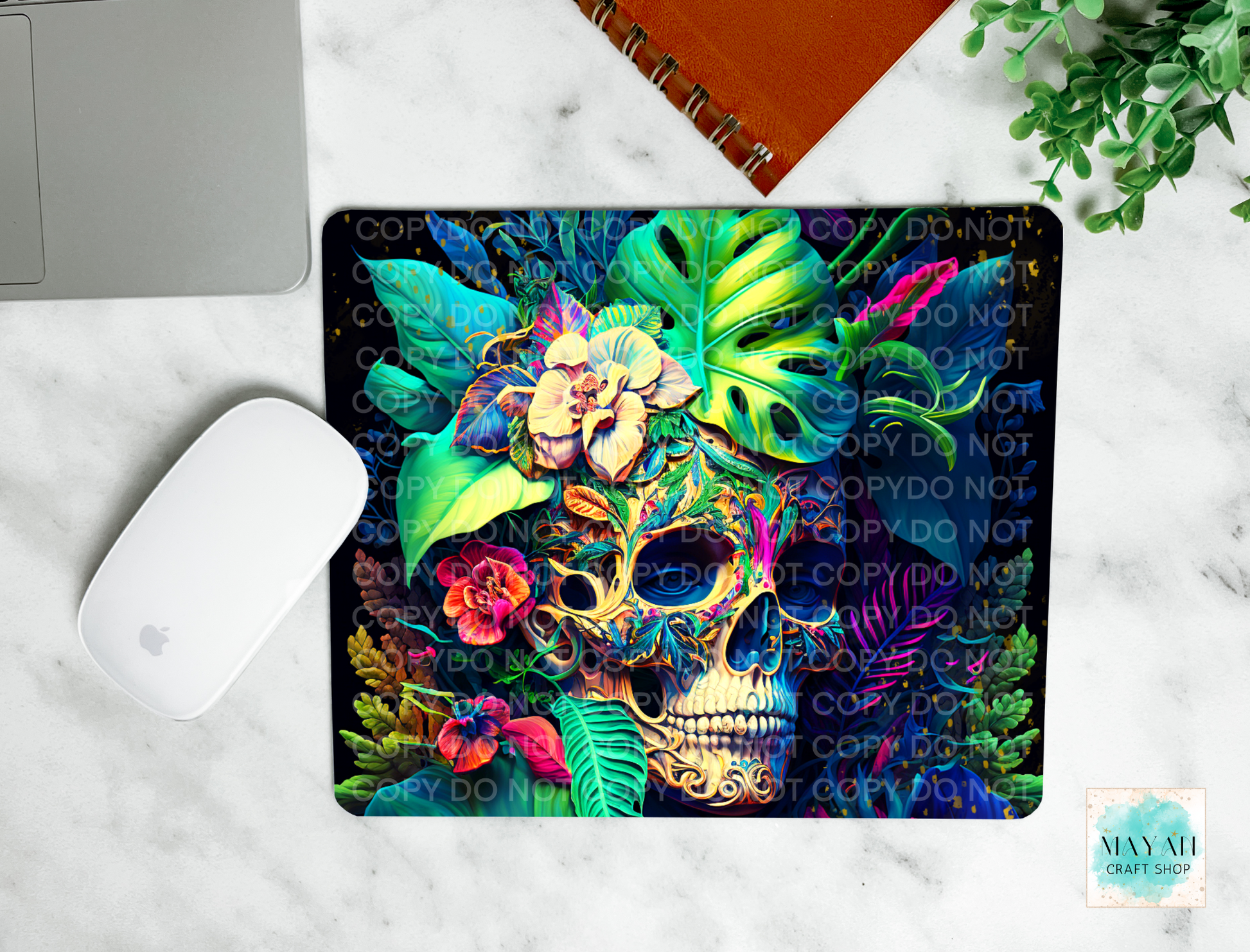 Colorful skull design mouse pad on a marble surface with a laptop and mouse.