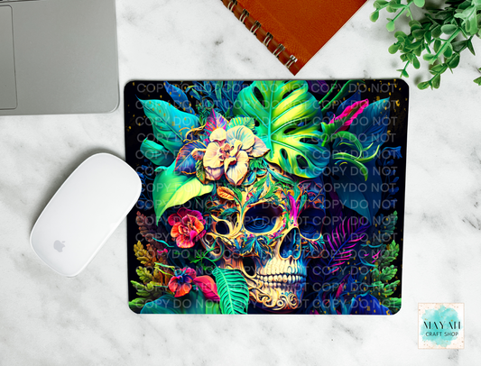 Colorful skull design mouse pad on a marble surface with a laptop and mouse.