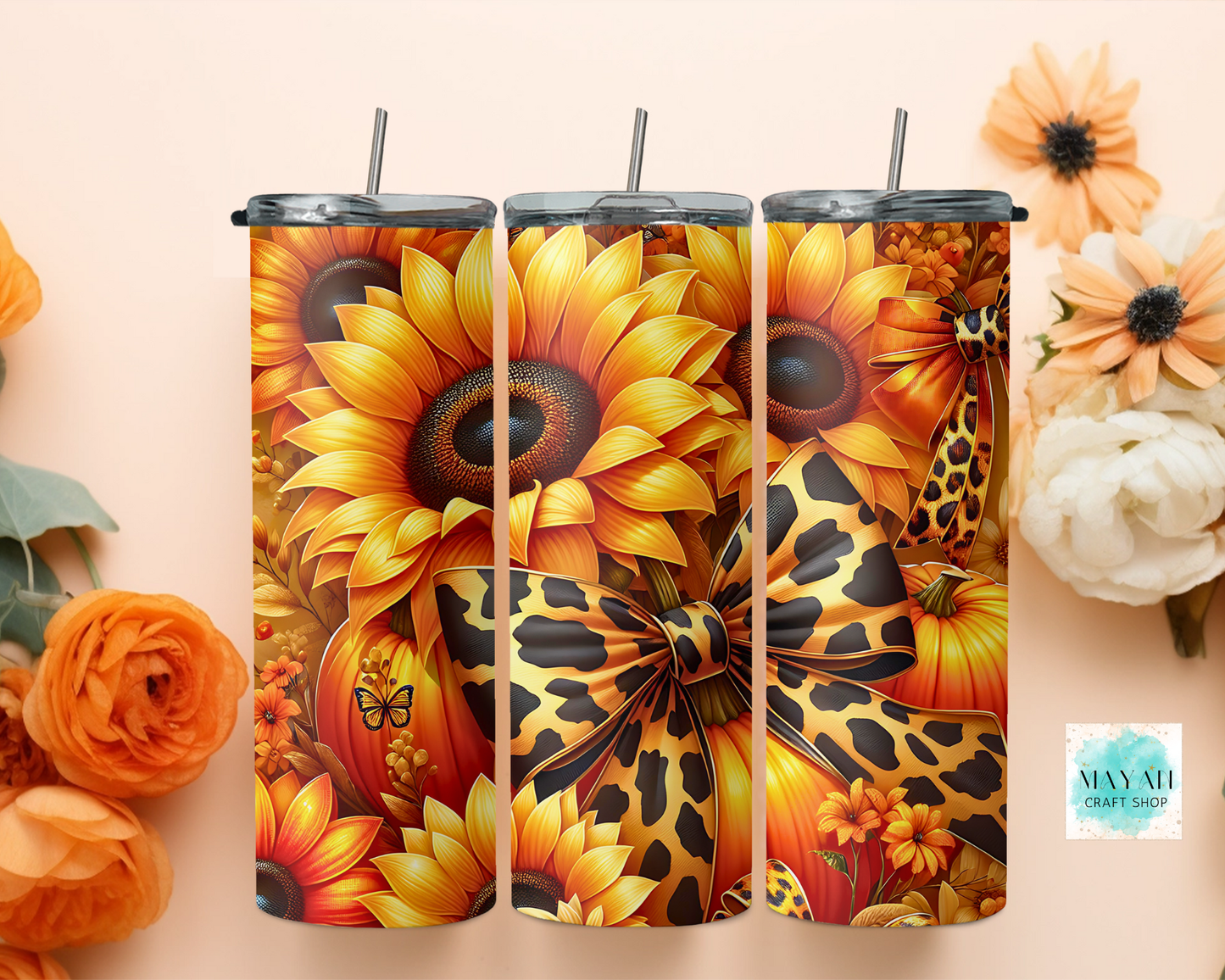 Three tumblers with sunflower and pumpkin designs on a beige background with flowers.