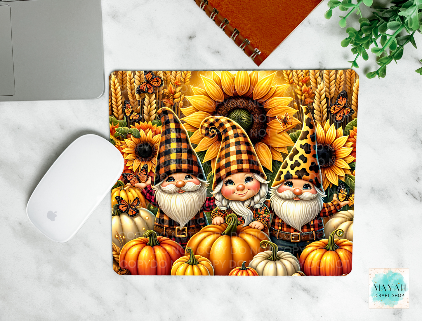 Mouse pad with autumn-themed design featuring gnomes, pumpkins, and sunflowers on a marble surface.