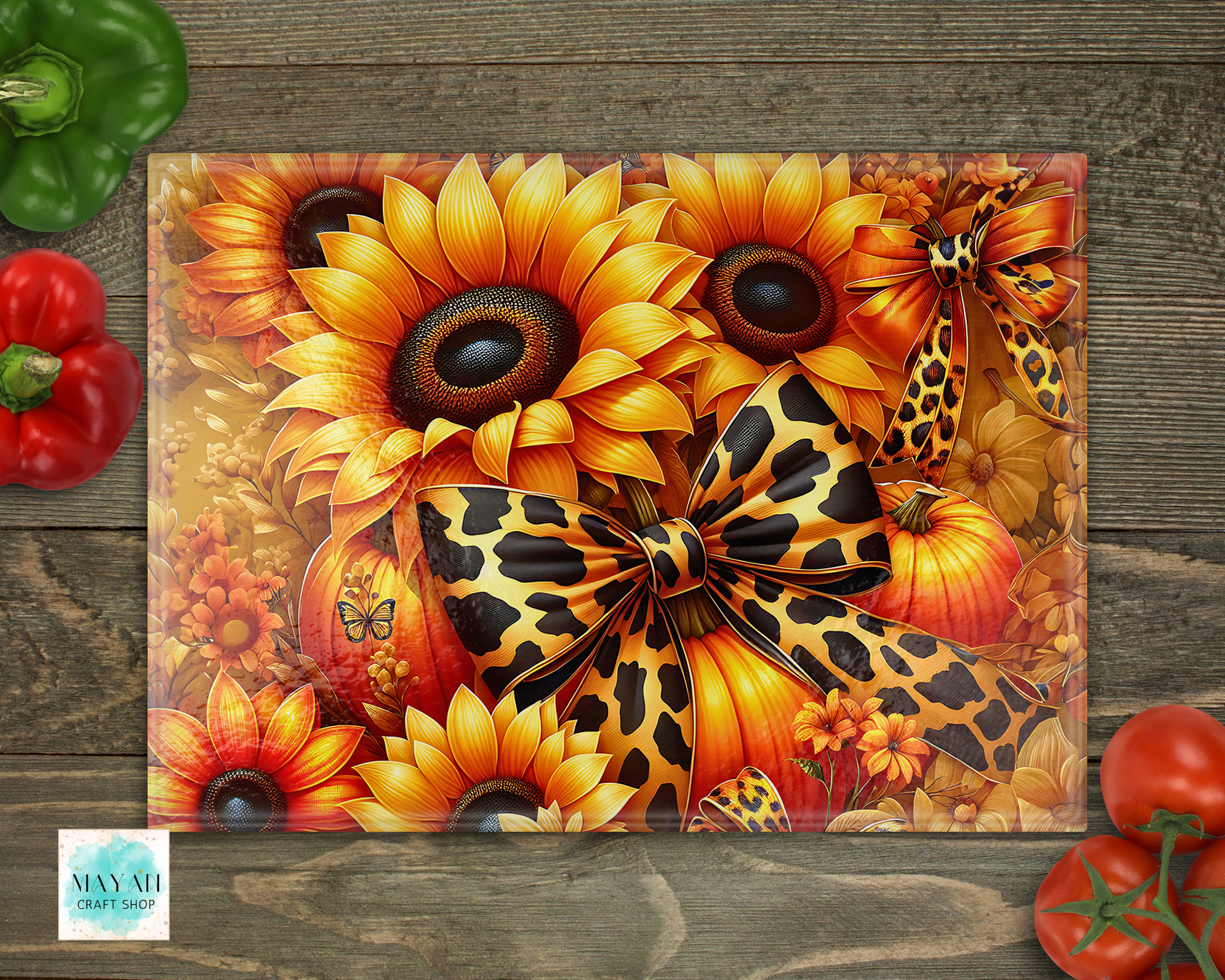 Decorative cutting board with sunflowers, pumpkins, and leopard print elements on a wooden surface.