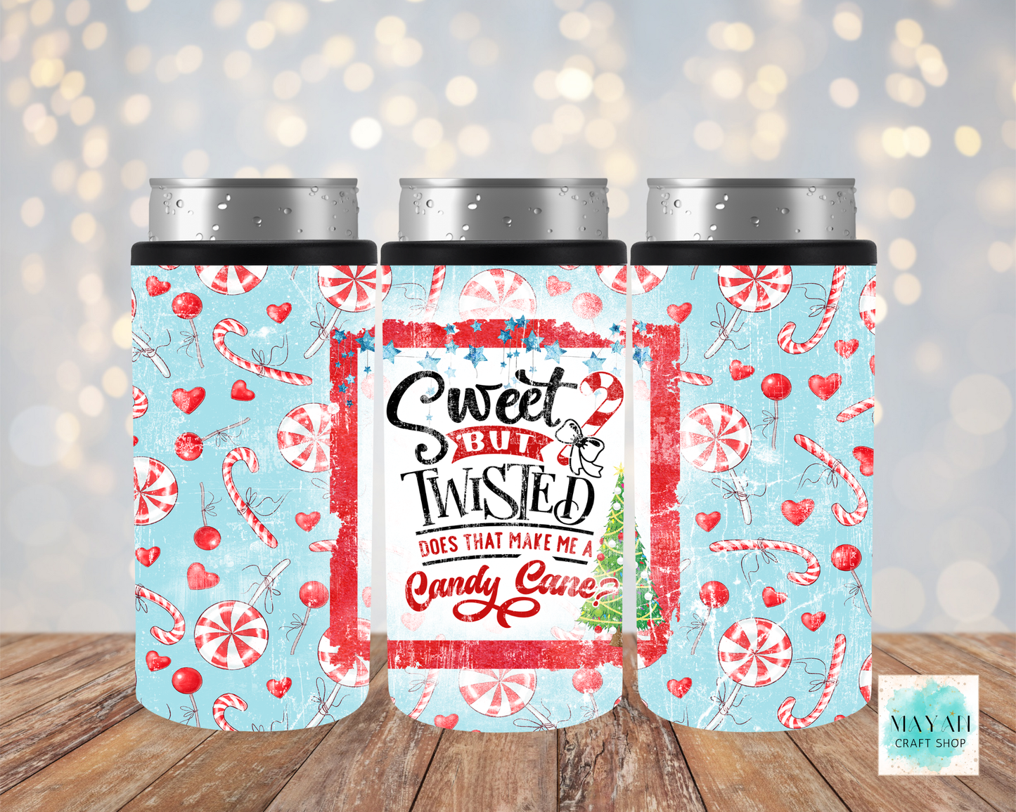 Three festive-themed tumblers with candy cane and heart patterns on a wooden surface.