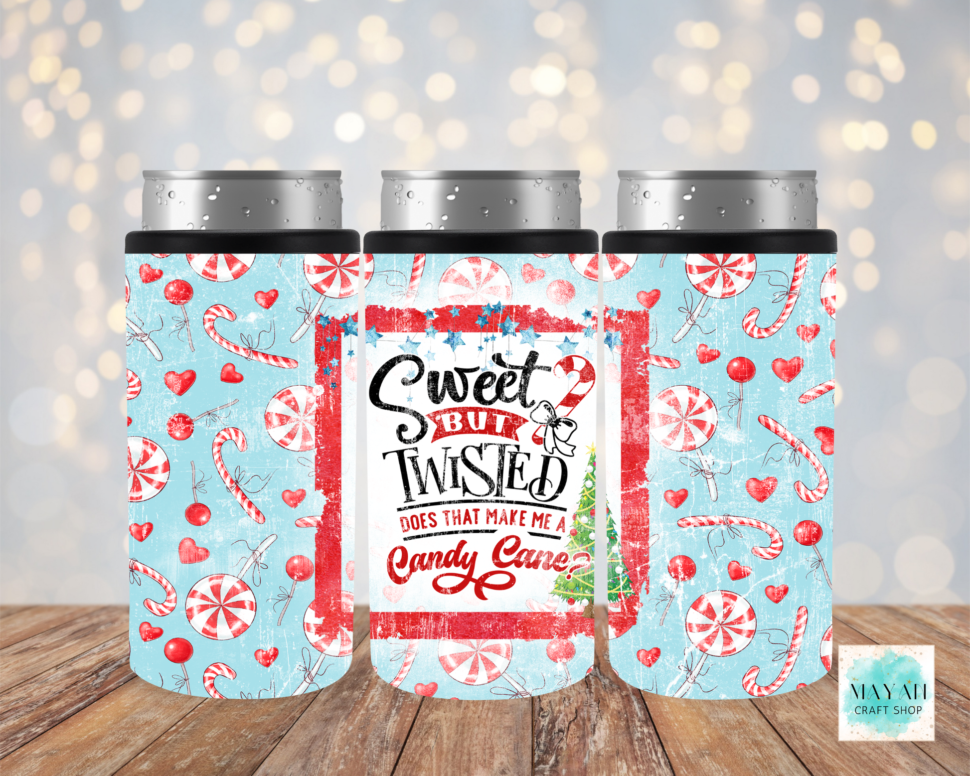 Three festive-themed tumblers with candy cane and heart patterns on a wooden surface.