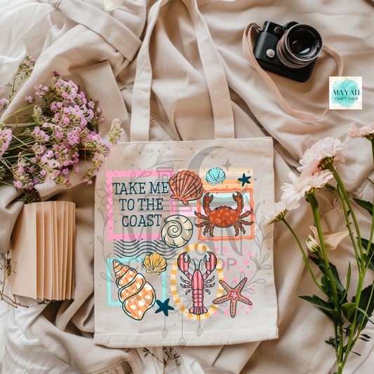 Tote bag with coastal design featuring shells, a crab, and a lobster on a soft fabric background.