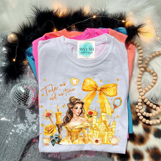 White t-shirt with princess design, surrounded by decorative items.