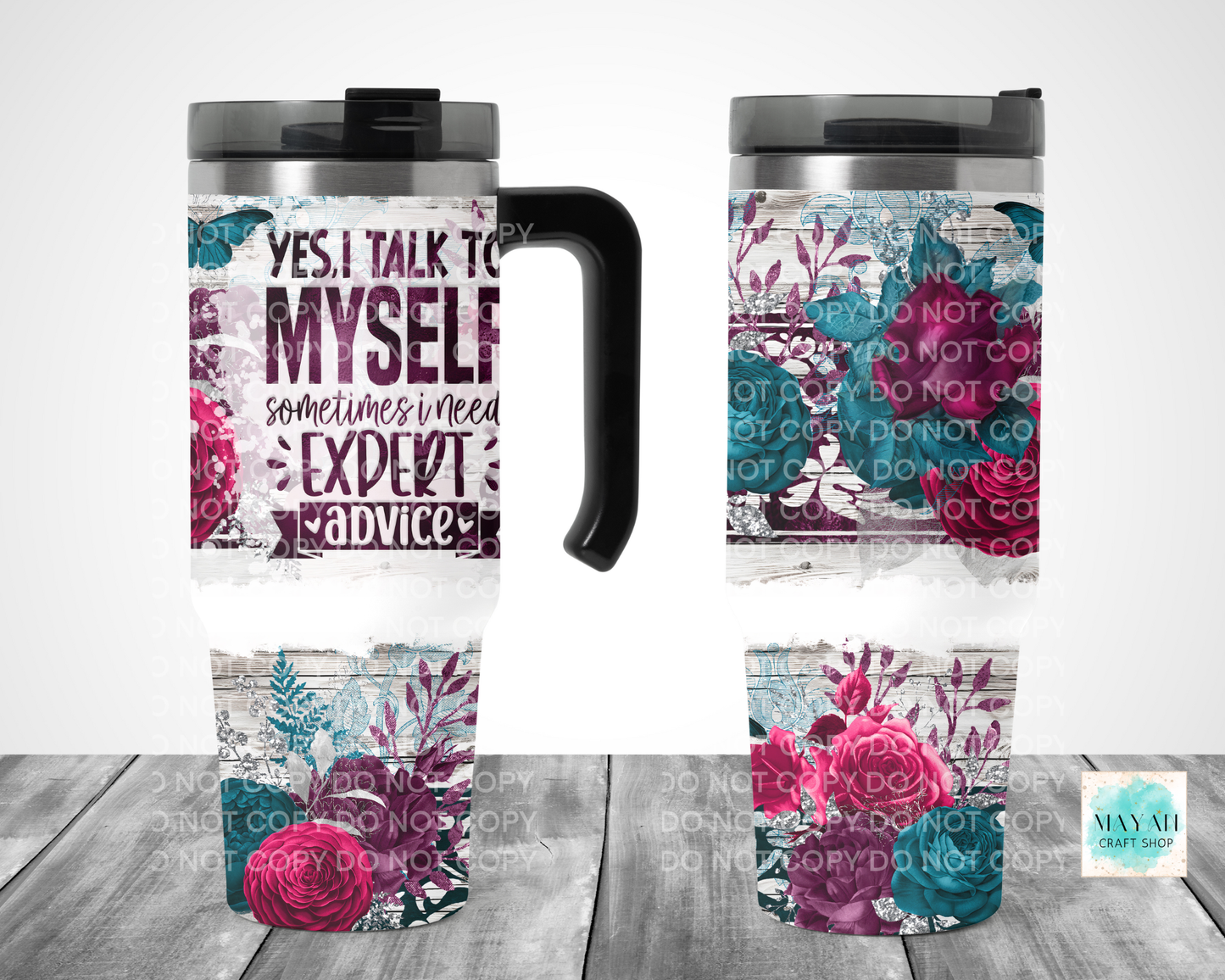 Travel mug with floral design and text on a wooden surface