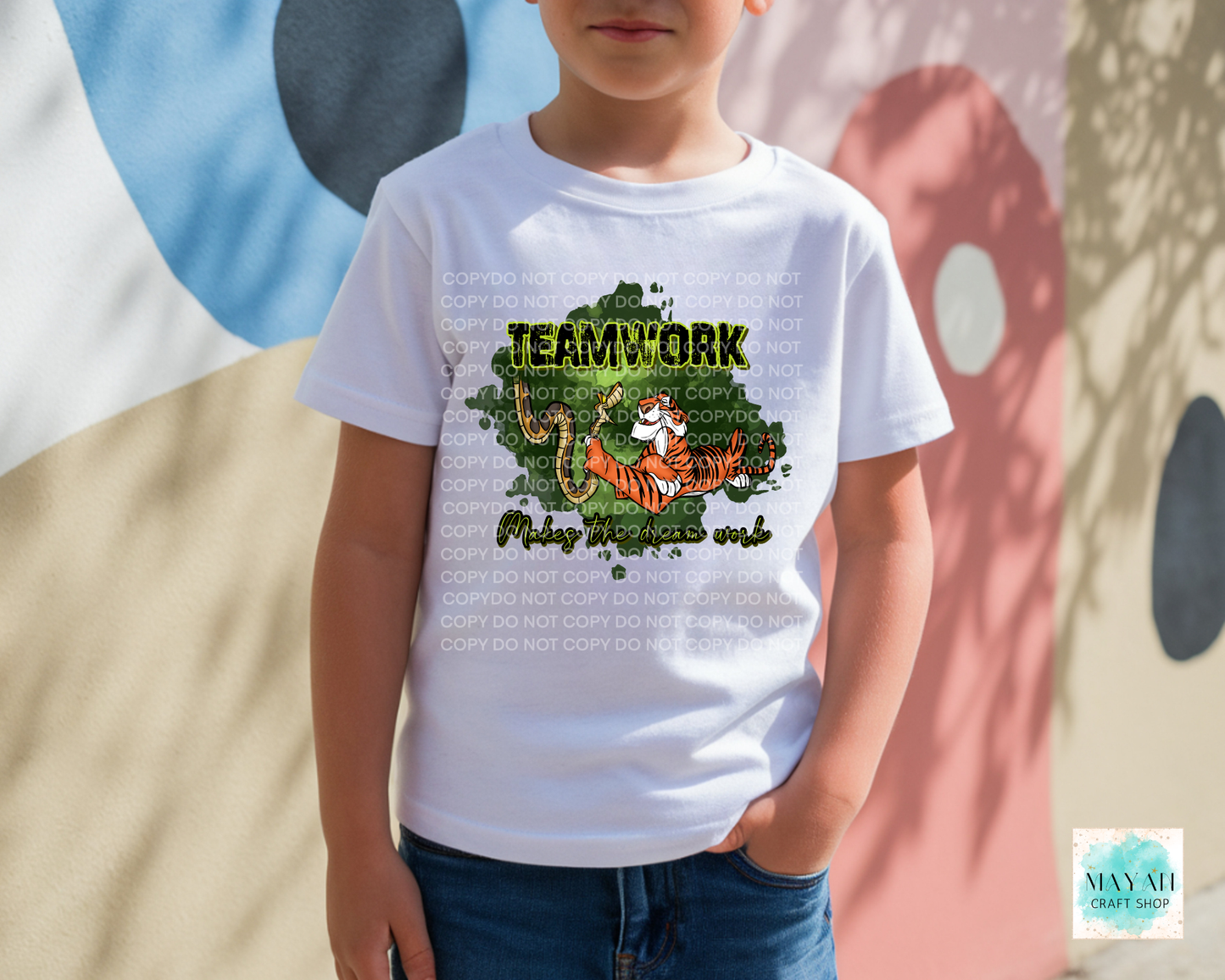 Child wearing a white t-shirt with a graphic and text, standing against a colorful abstract background.
