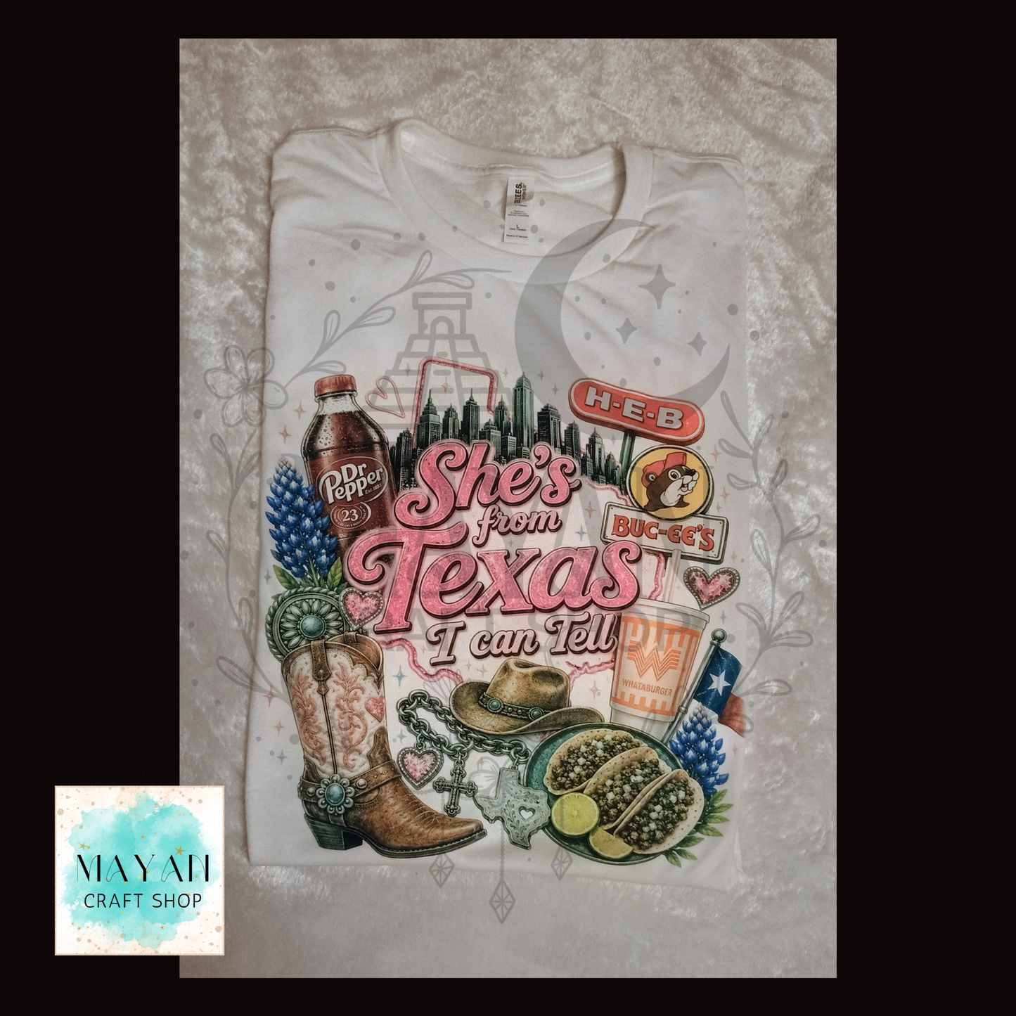 White t-shirt with Texas-themed graphics and text on a textured surface.