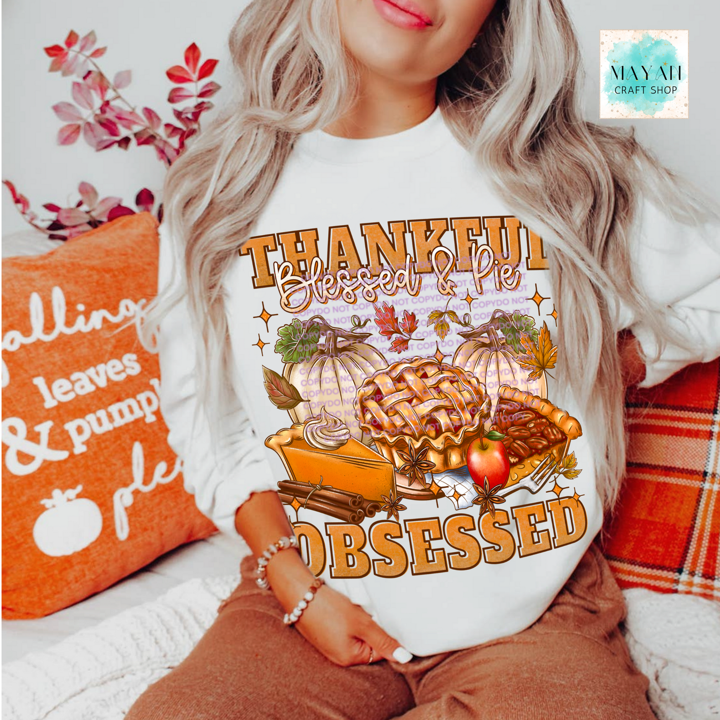 Person wearing a shirt with 'Thankful, Blessed & Pie Obsessed' design in a cozy setting.
