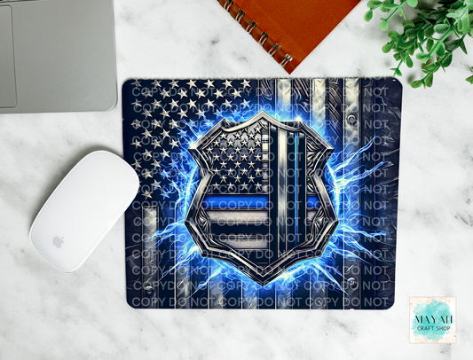 Mouse pad with American flag and police badge design on a marble surface.