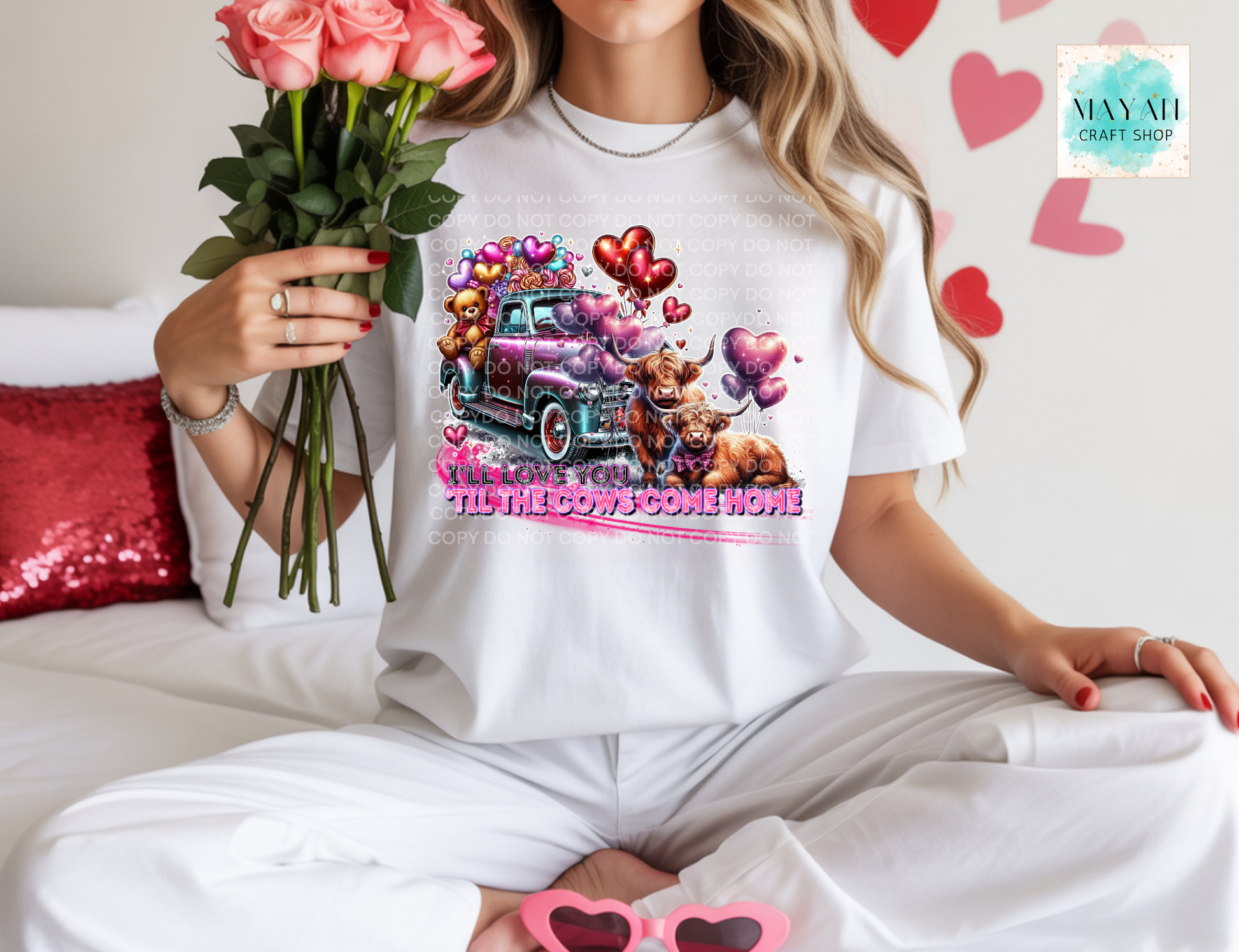 Person wearing a white t-shirt with a graphic design, holding flowers, and sitting on a couch.
