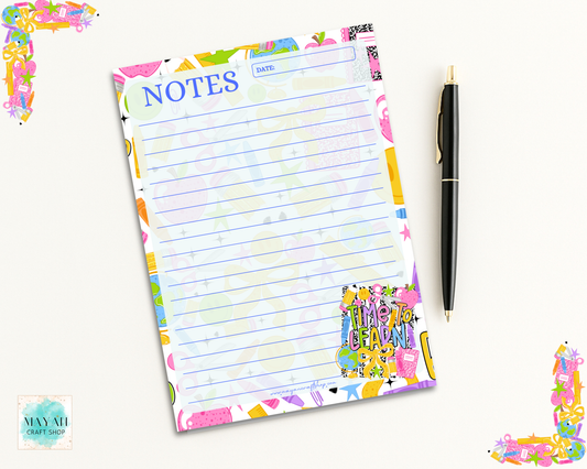 A pastel-colored lined notes pad with a colorful floral border and a black pen on a light cream background.