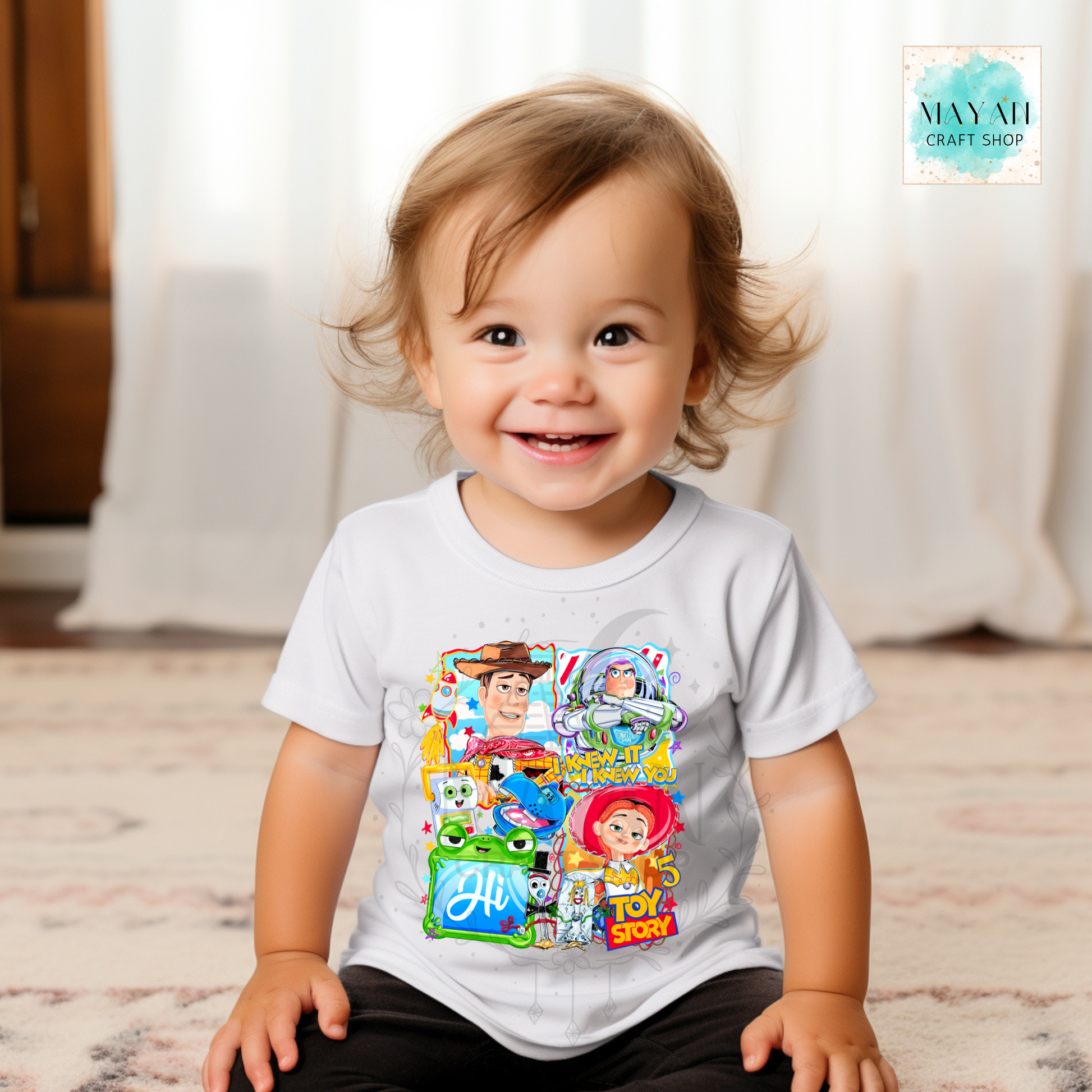 Child wearing a character t-shirt with colorful graphics, sitting on a wooden floor.