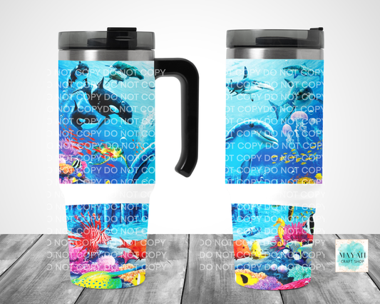 Travel mug with an underwater scene design on a wooden surface.