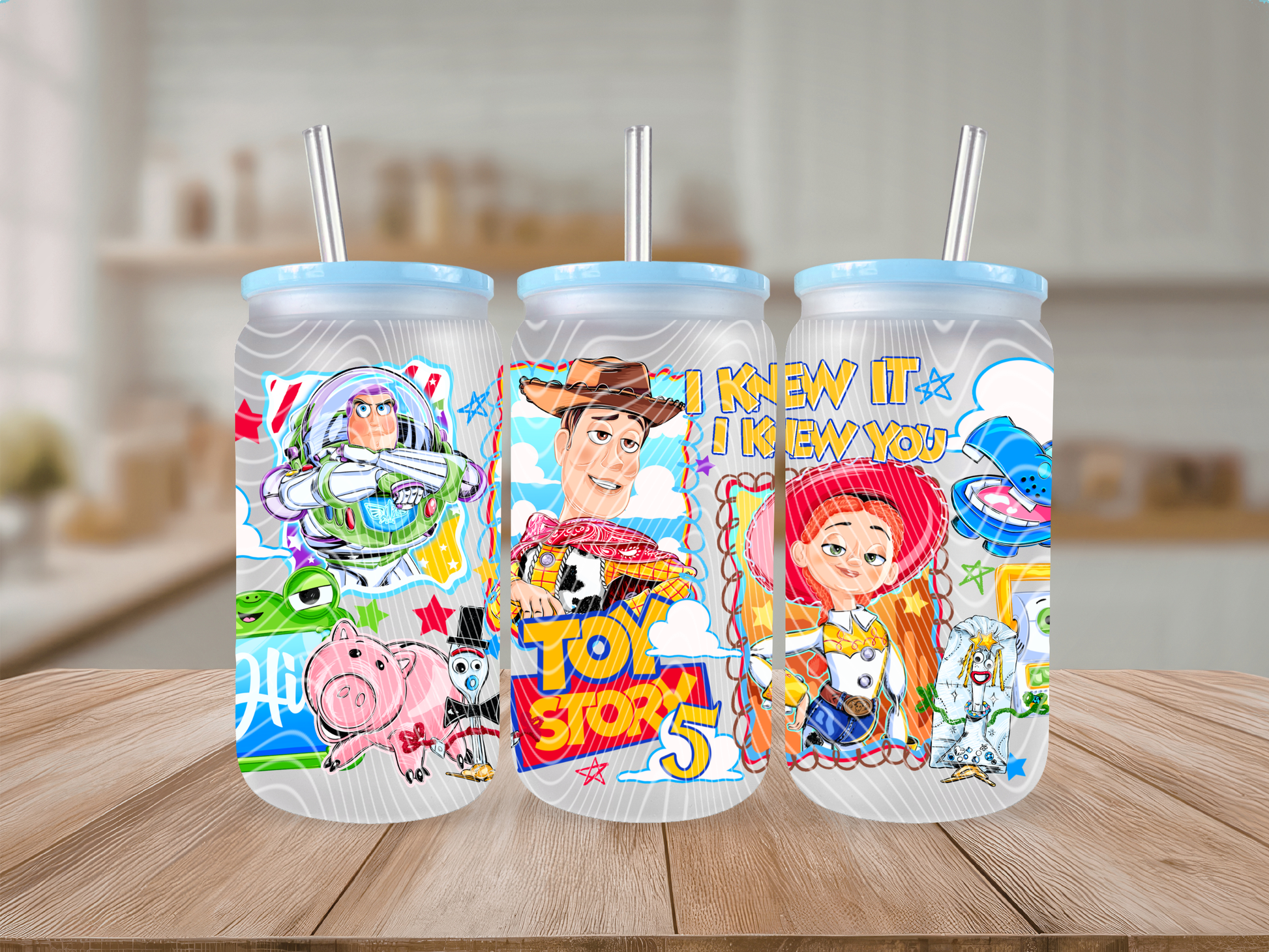Three frosted glass cans with character illustrations on a wooden surface.