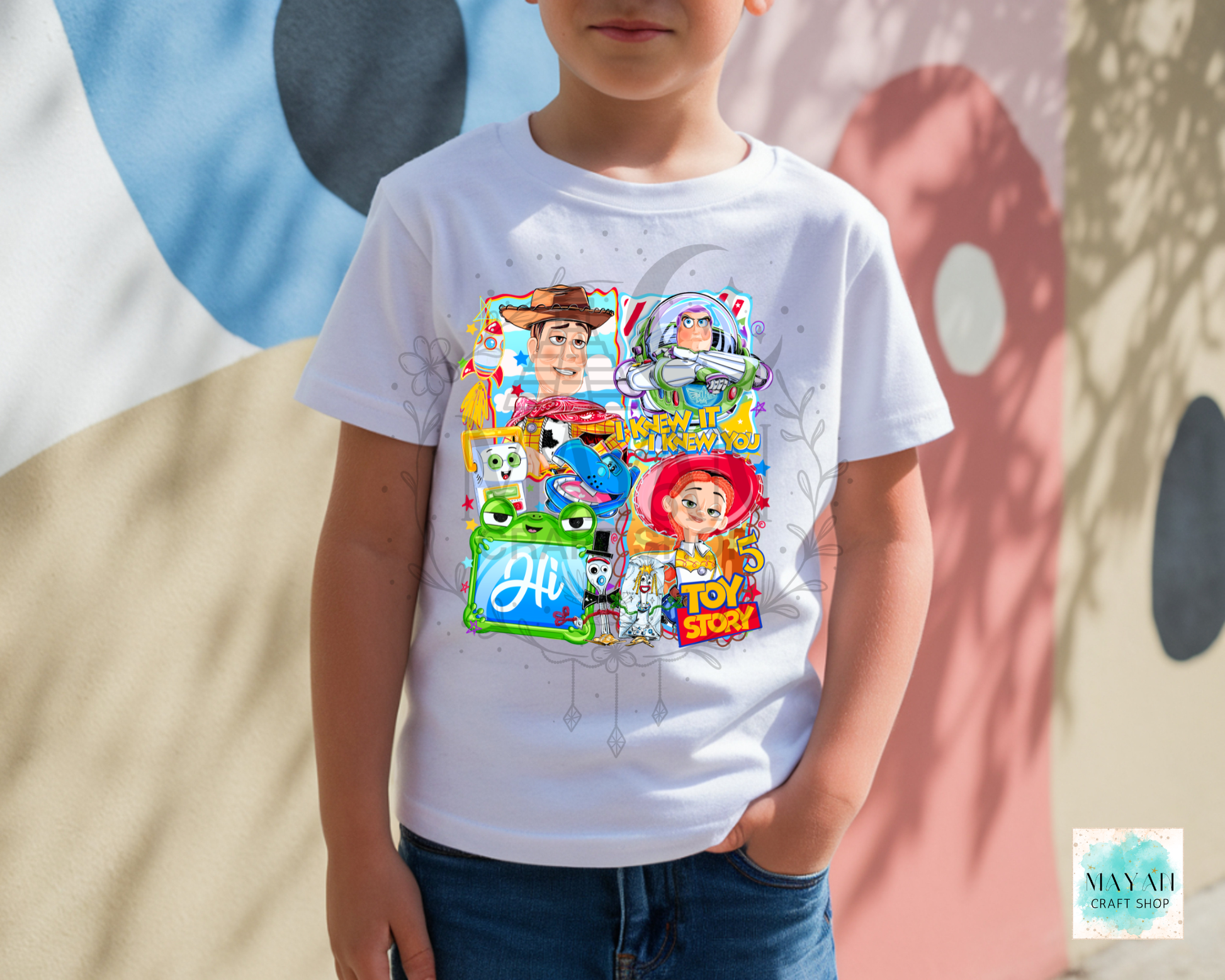 Child wearing a white t-shirt with  character graphics against a colorful abstract background.
