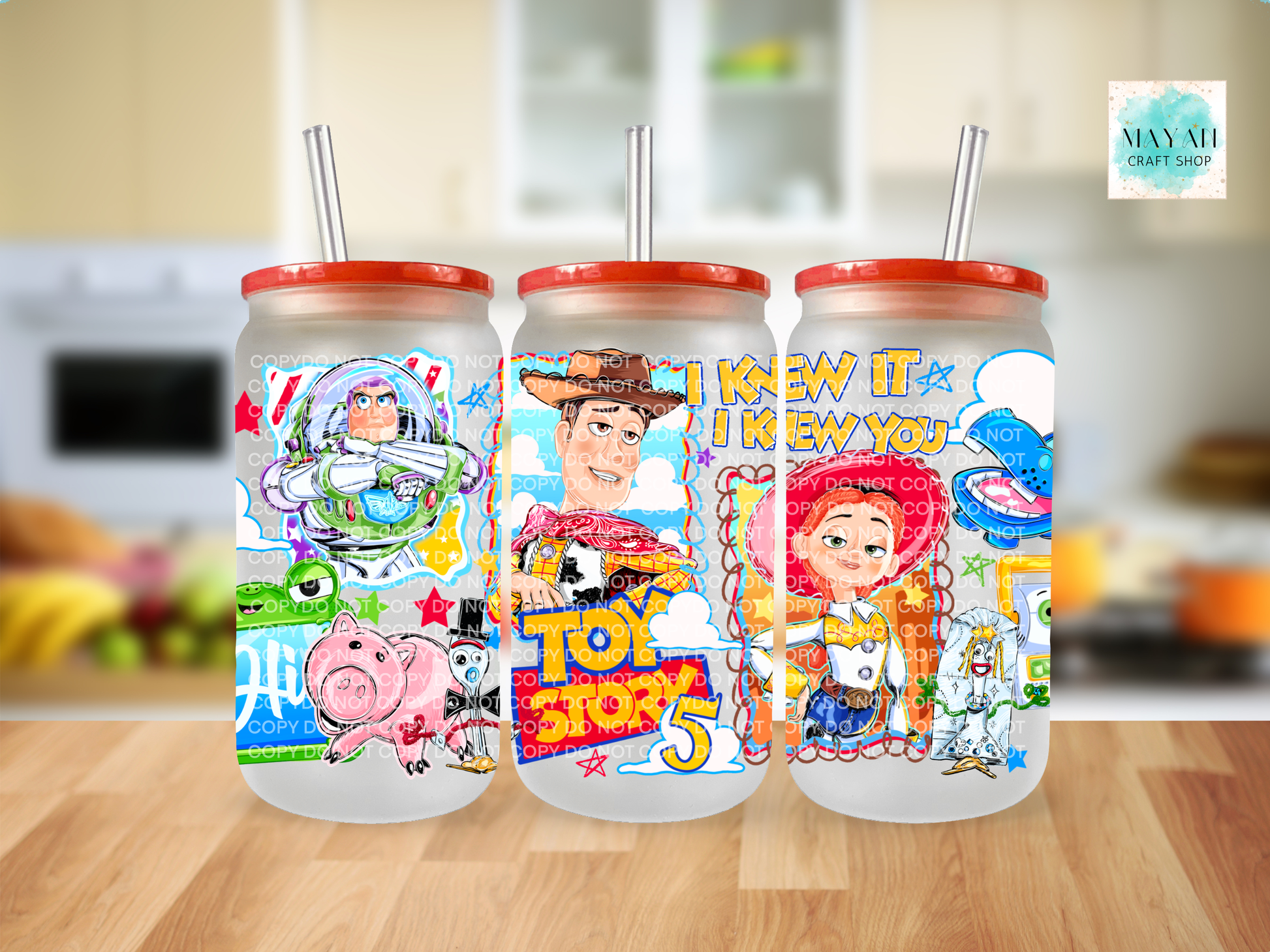 Three colorful tumblers with cartoon characters on a wooden surface.