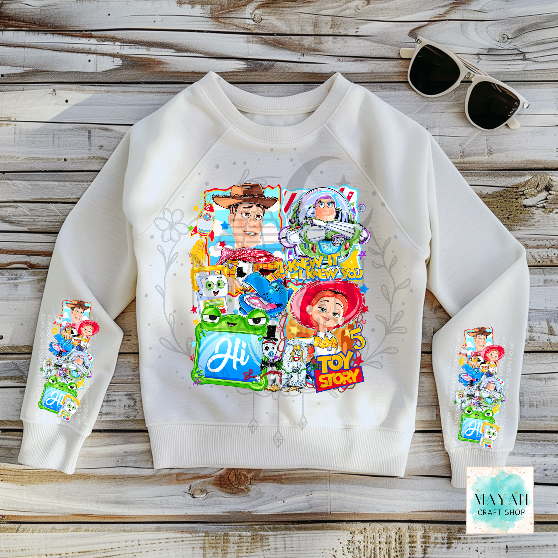 White sweatshirt with character graphics on a wooden surface