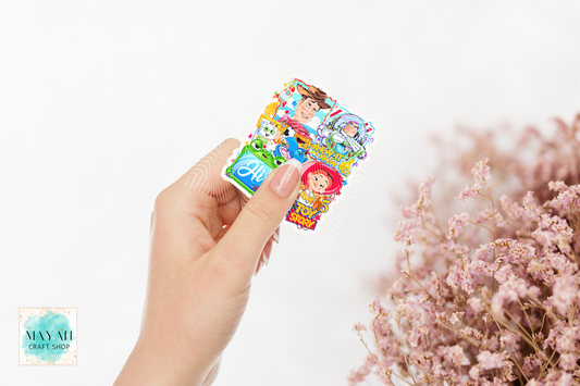 Hand holding a colorful sticker sheet with cartoon characters on a white background.