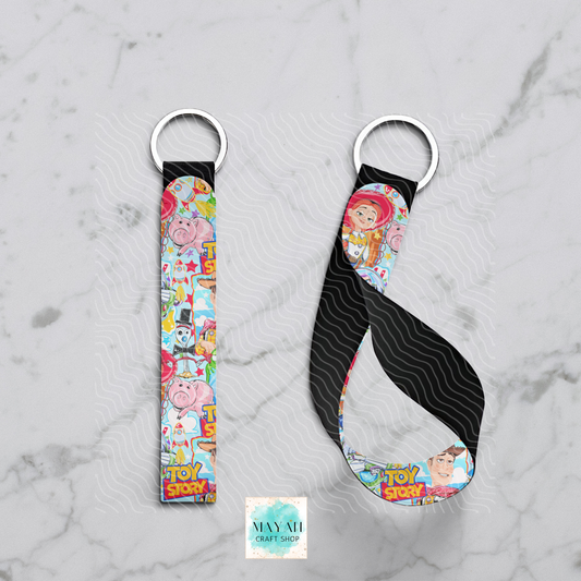Two keychains with colorful designs on a marble surface, featuring characters.