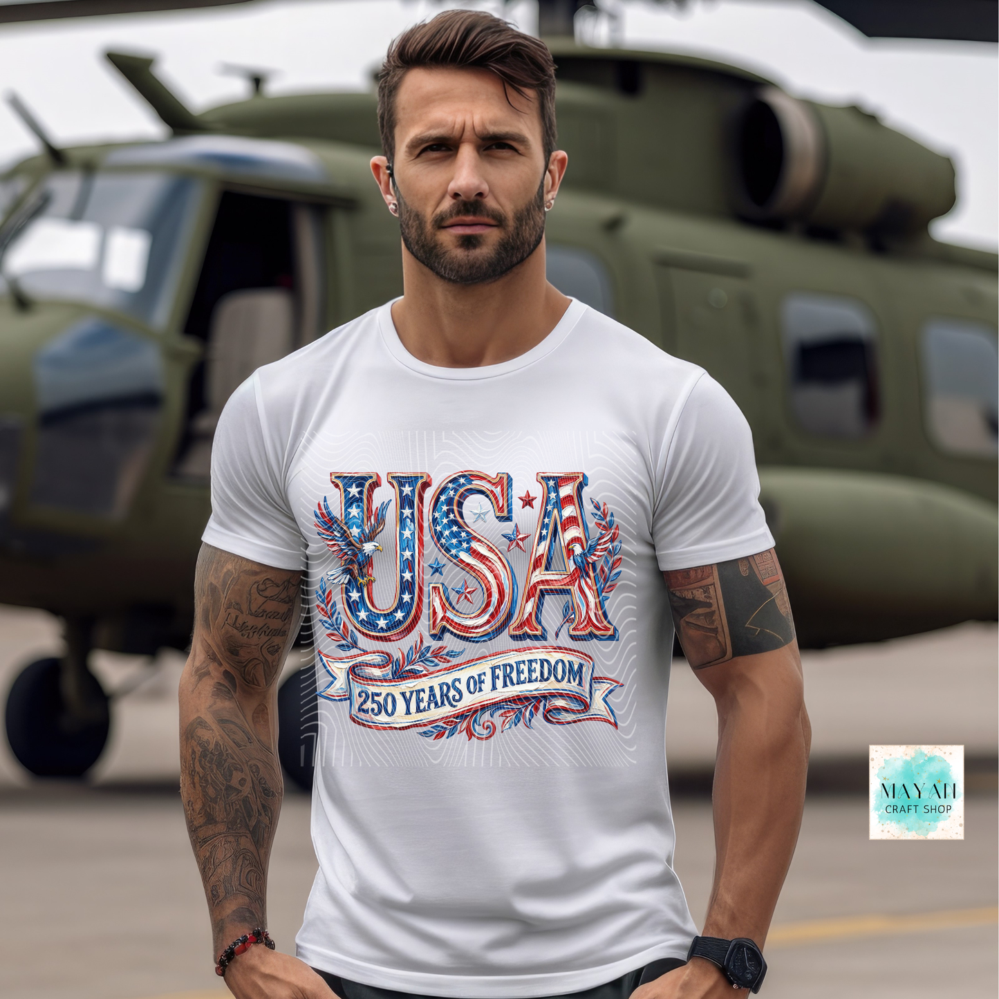 Man wearing a white t-shirt with 'USA 250 Years of Freedom' design in front of a helicopter.