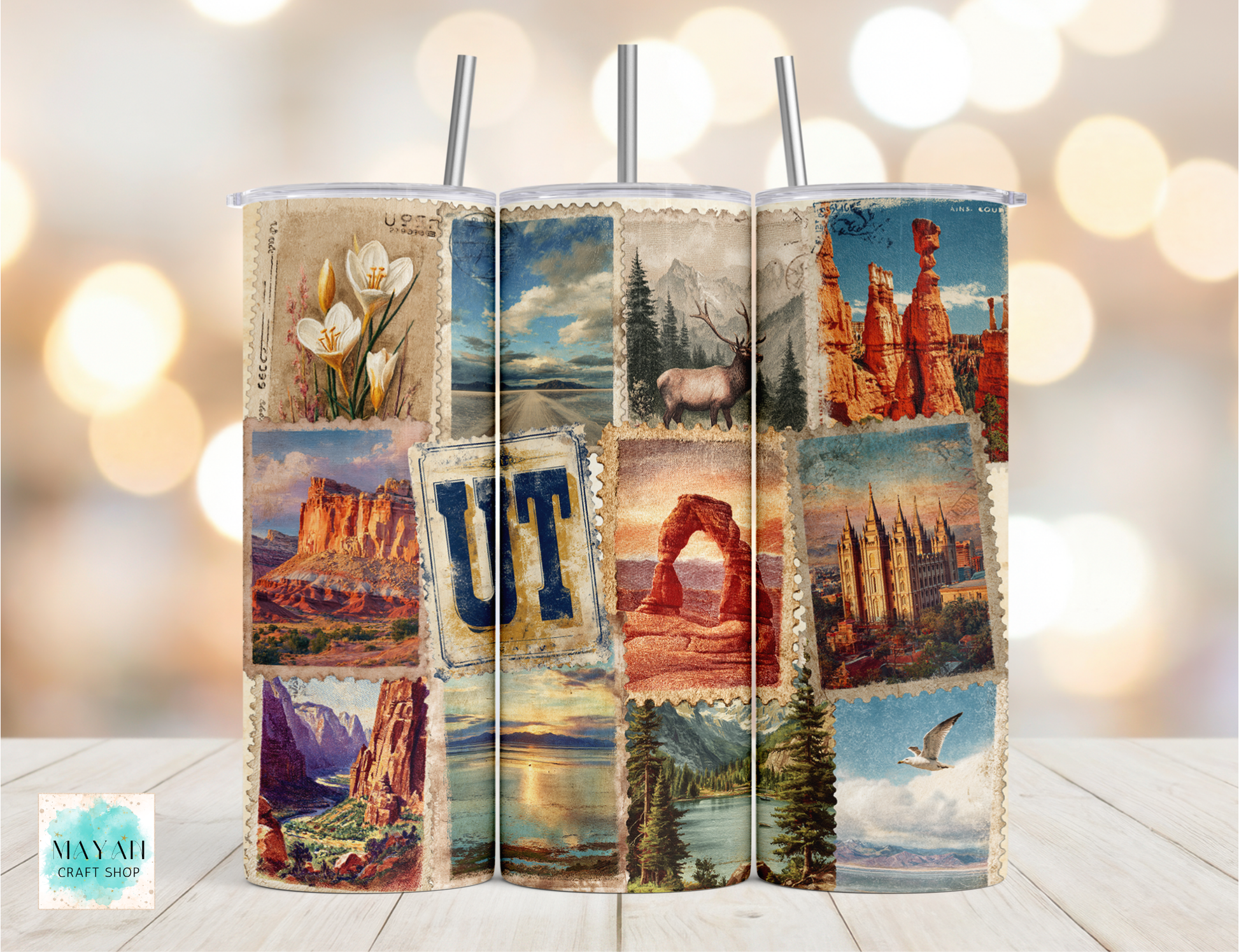 Tumbler with scenic designs and 'UT' on a wooden surface with blurred lights in the background