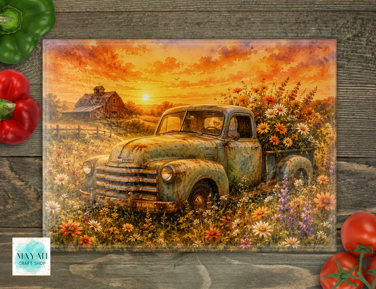 Cutting board with an old truck and sunset over a field design, placed on a wooden surface with vegetables.
