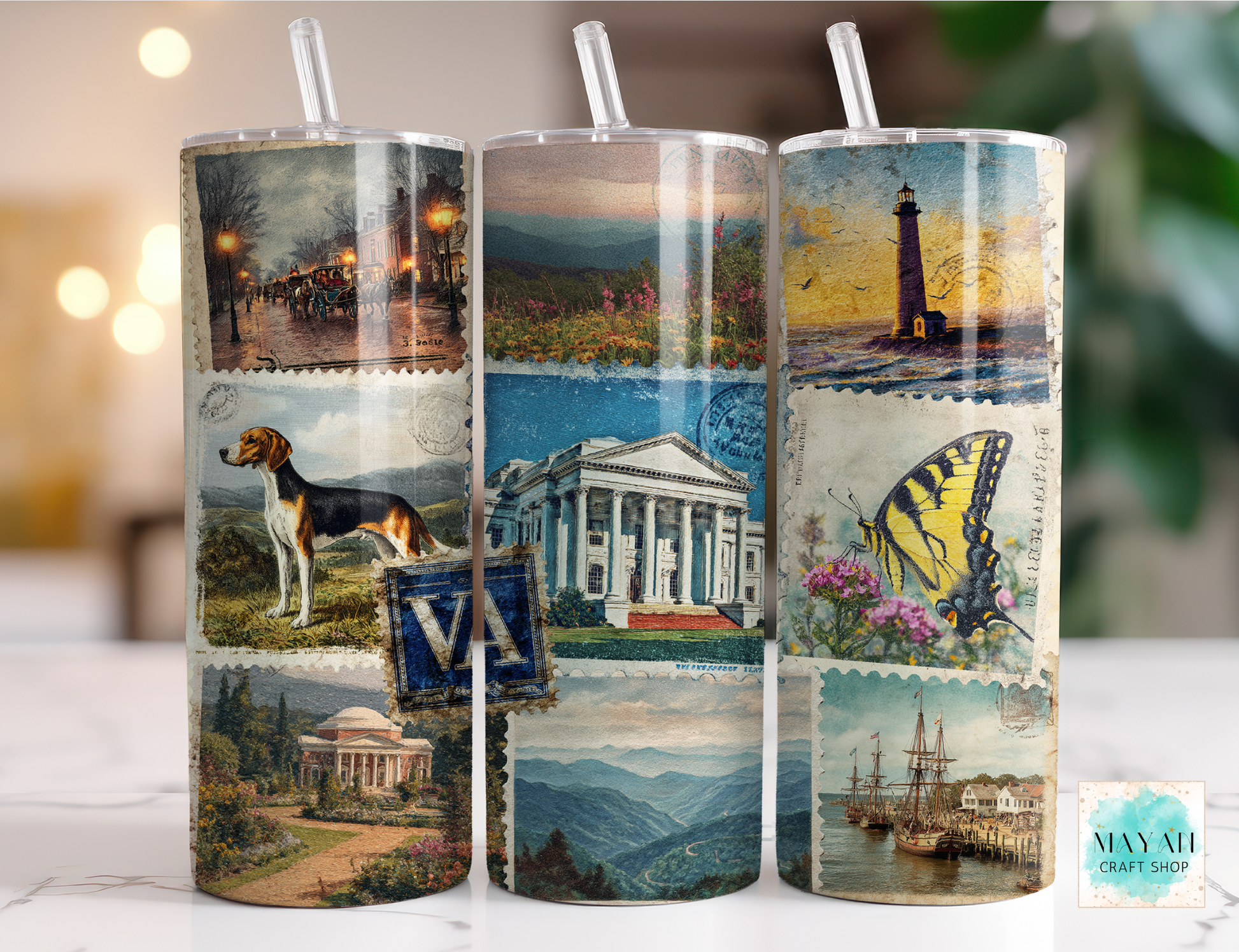 Three cylindrical tumblers with scenic and vintage designs on a blurred background