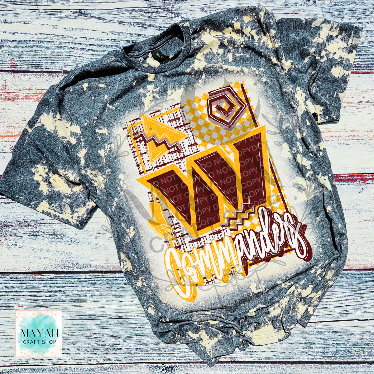 A short-sleeve graphic T-shirt laid flat on a distressed whitewashed wood background. The shirt has a heather charcoal bleached pattern with a large front graphic featuring a stylized letter W, geometric patterns.