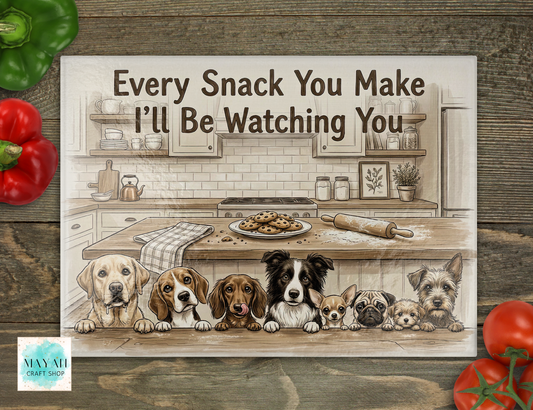 cutting board of dogs in a kitchen with text 'Every Snack You Make I'll Be Watching You' on a wooden surface.