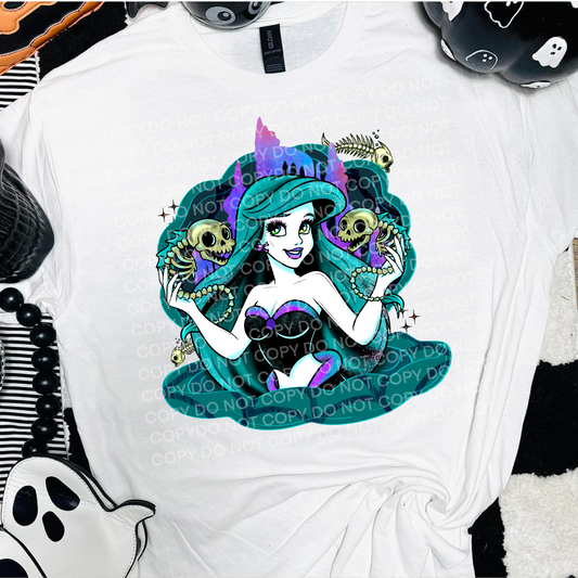 White t-shirt with a stylized mermaid design featuring skeletons and colorful elements.