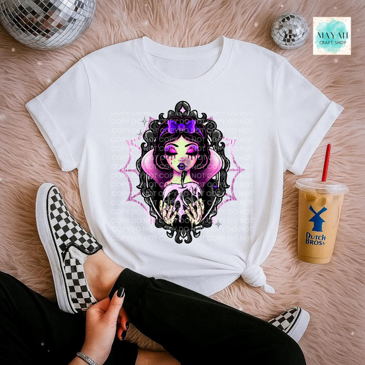 White t-shirt with a colorful graphic design on a pink surface with a drink and shoes.