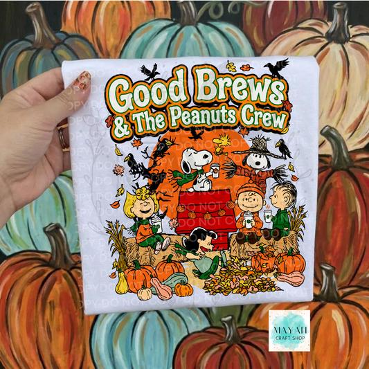 A hand holds a white t-shirt featuring a colorful cartoon graphic of an inspired characters and pumpkins with a text . The background is a painted pattern of pumpkins