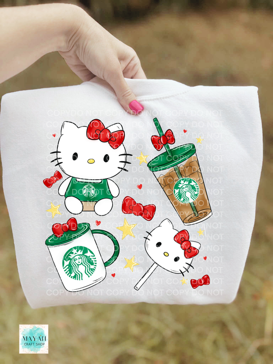 White sweatshirt with cat and coffee-themed designs held by a hand.
