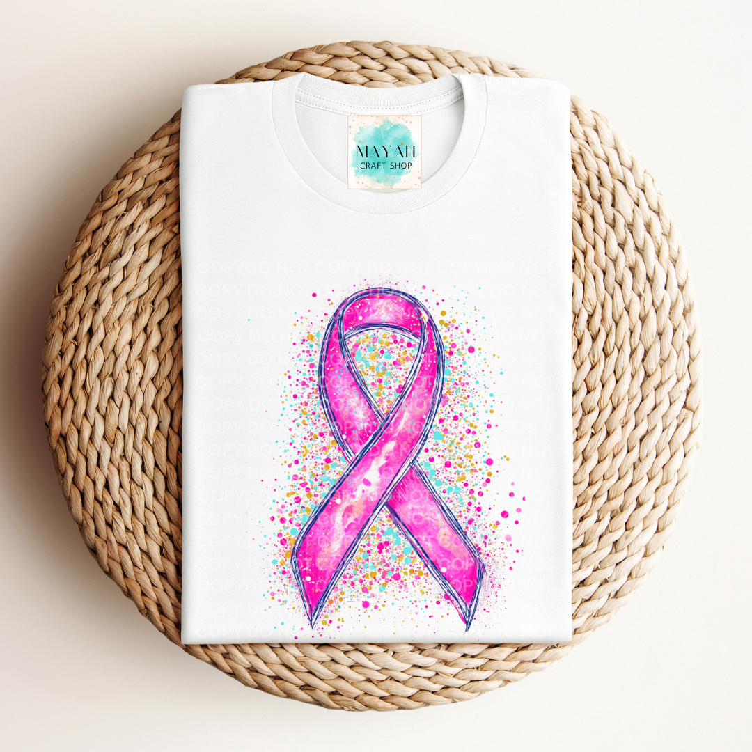 White t-shirt with pink ribbon design on a woven mat