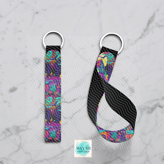 Colorful yoga strap with a black background on a gray marble surface, featuring the Mayan Craft Shop logo.