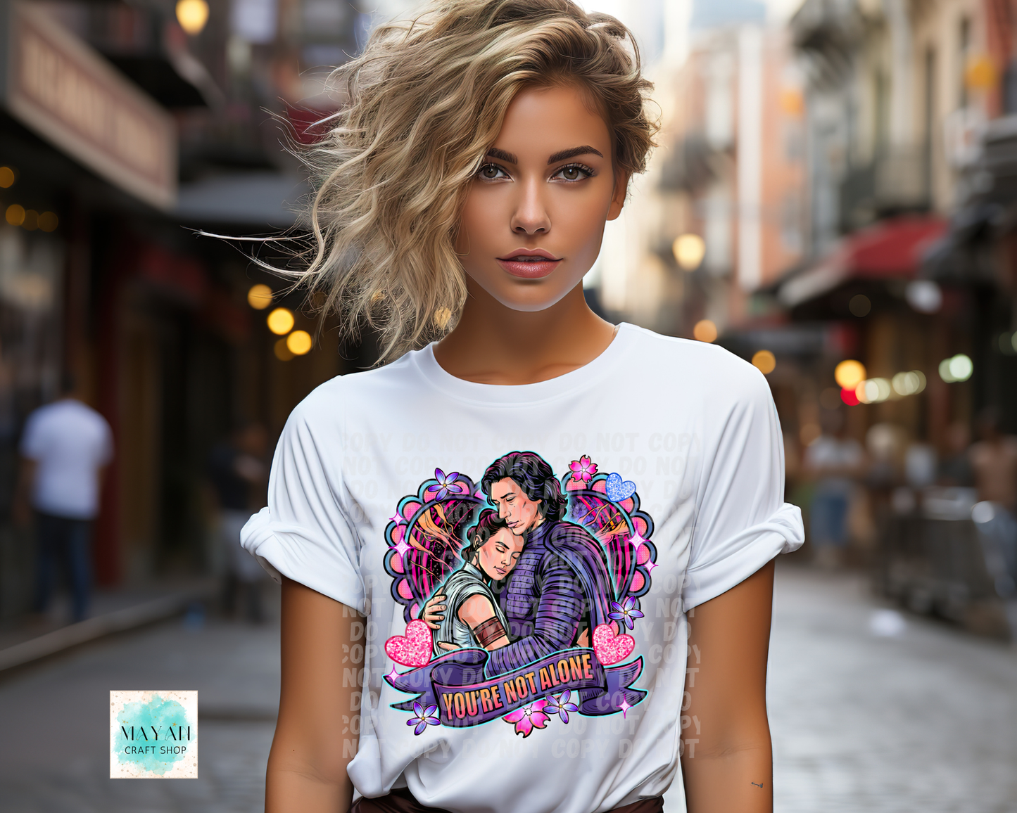 Woman wearing a white t-shirt with a colorful graphic design on a city street.