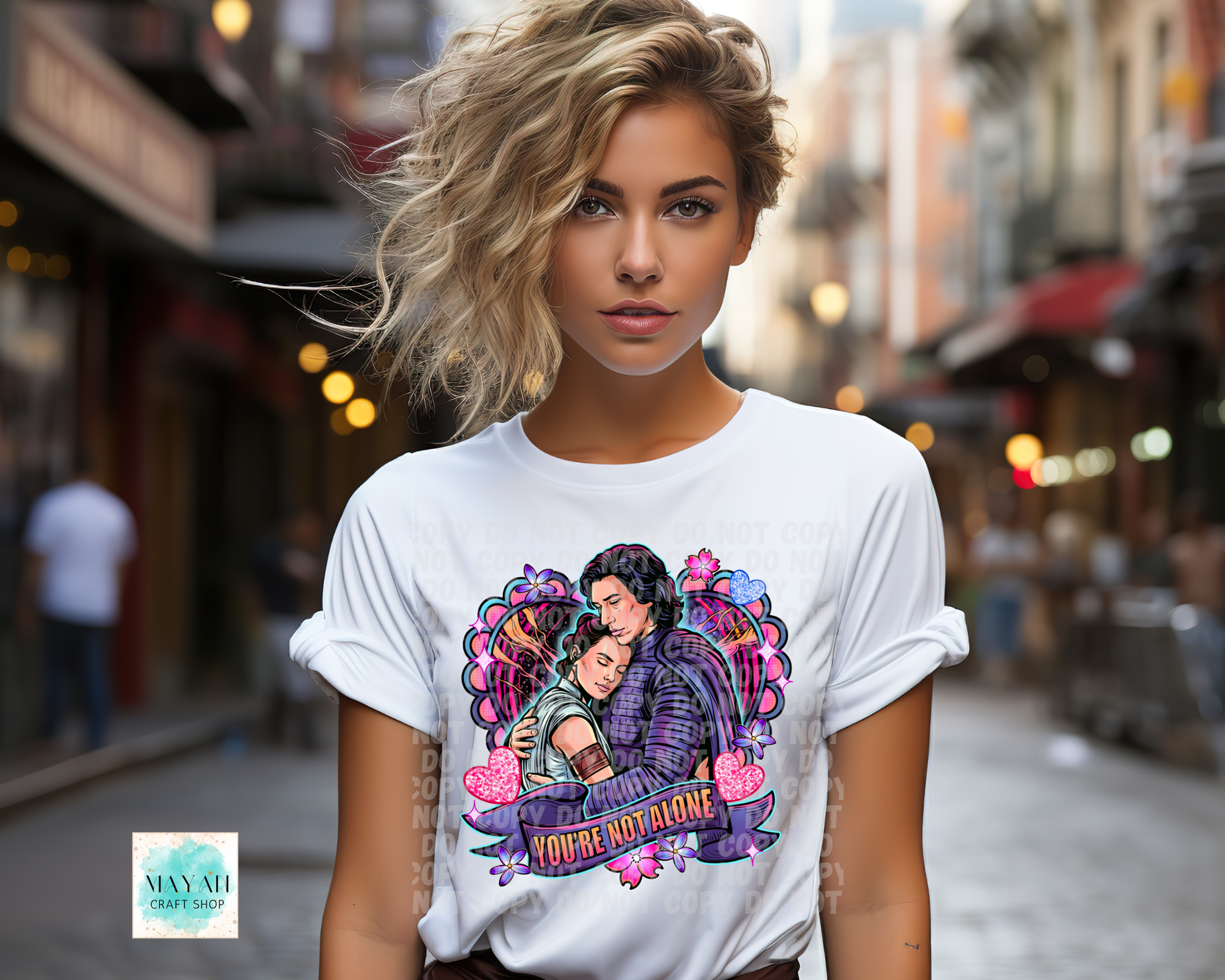 Woman wearing a white t-shirt with a colorful graphic design on a city street.
