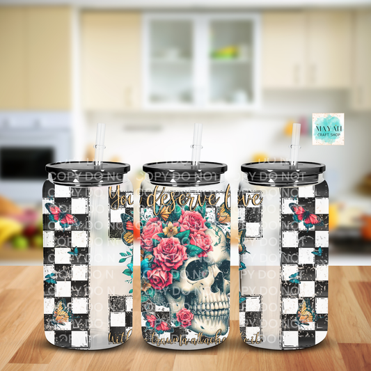Three tumblers with floral and skull designs on a kitchen counter.